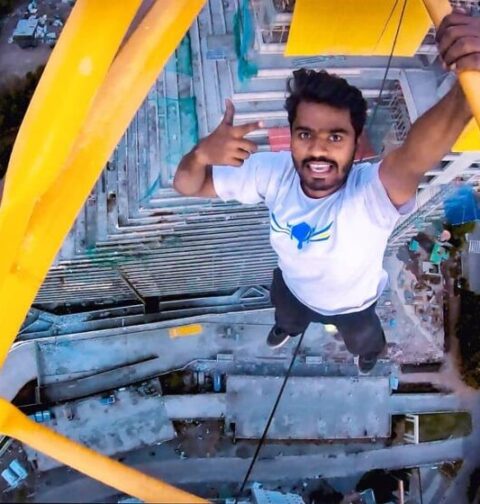 FIRST-PERSON TO HANG WITH ONE HAND ON BUILDING CRANE AT MAXIMUM HEIGHT